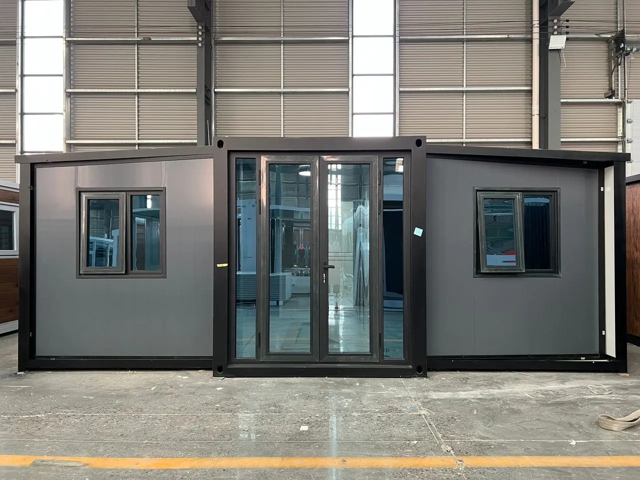 Casa plegable gris expandida en fábrica